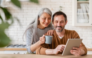 Smiling middle-aged couple looking at a tablet for new home