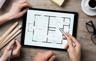 Architects looking at blueprint designs on digital tablet