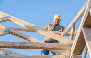 man building house and smiling